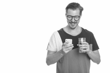 Bıyıklı, beyaz arka planlı, siyah beyaz bir genç adamın stüdyo fotoğrafı.