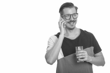 Bıyıklı, beyaz arka planlı, siyah beyaz bir genç adamın stüdyo fotoğrafı.