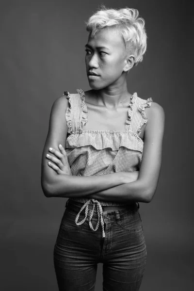 在黑色和白色的灰色背景下短发的年轻美丽叛逆的亚洲妇女的工作室镜头 — 图库照片