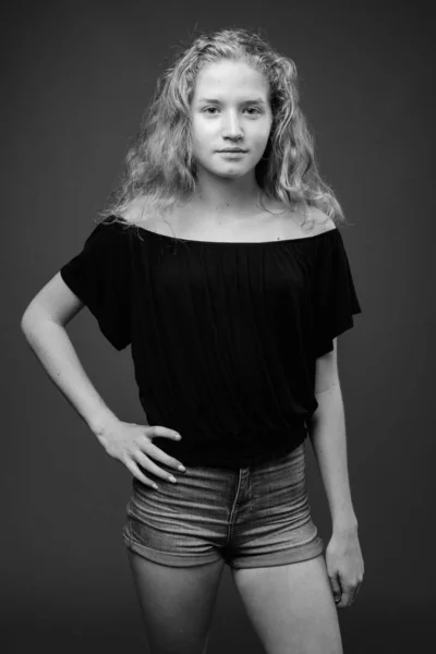 演播室拍摄的年轻美丽的金发少女与灰色背景的黑白照片 — 图库照片