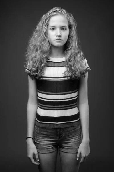 演播室拍摄的年轻美丽的金发少女与灰色背景的黑白照片 — 图库照片