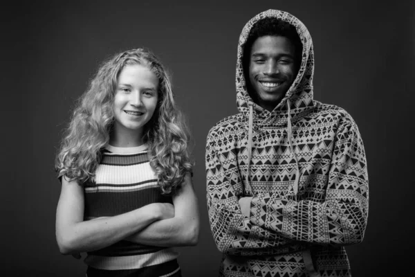 非洲青年男子与少女在黑白灰色背景下在演播室合影 — 图库照片