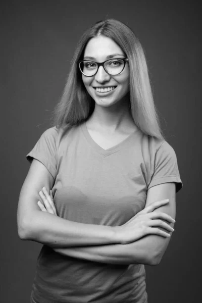 Studio shot of young beautiful woman against gray background — Stock Photo, Image