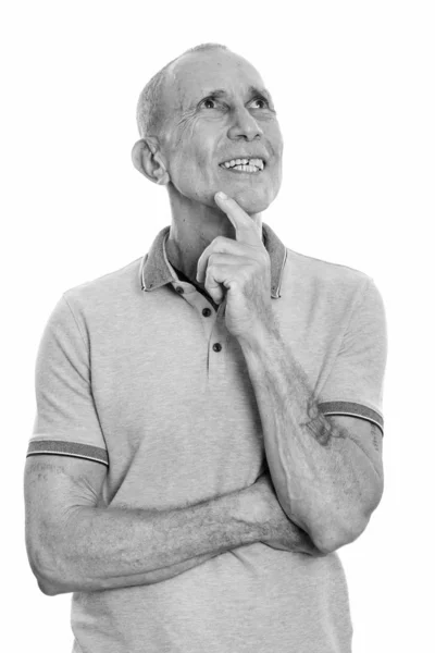 Studio shot of happy senior man smiling while thinking — Stock Photo, Image