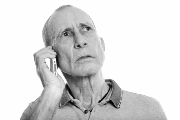 Крупним планом старший чоловік розмовляє по мобільному телефону, думаючи — стокове фото