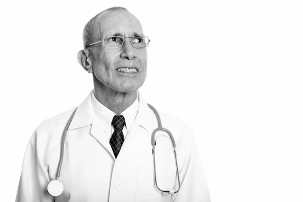 Estudio de tiro de feliz anciano médico sonriendo mientras pensaba —  Fotos de Stock