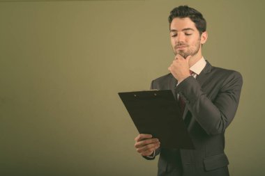 Genç yakışıklı işadamı renkli bir takım elbise giyiyor.