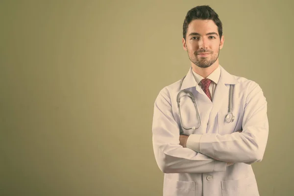 Joven hombre guapo médico contra el fondo de color — Foto de Stock