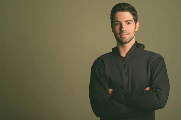 Jovem homem bonito usando capuz contra fundo colorido — Fotografia de Stock