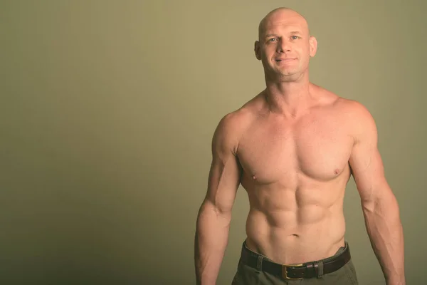 Bald muscular man shirtless against colored background — Stock Photo, Image
