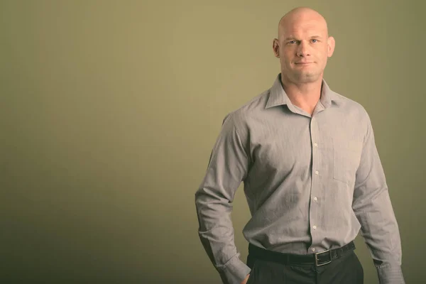 stock image Portrait of bald businessman against colored background