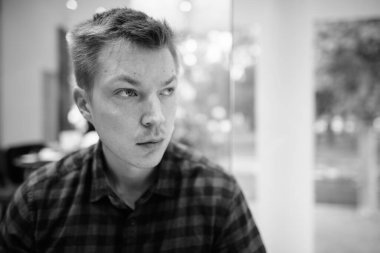 Portrait of young handsome tourist man exploring Ho Chi Minh city in Vietnam in black and white
