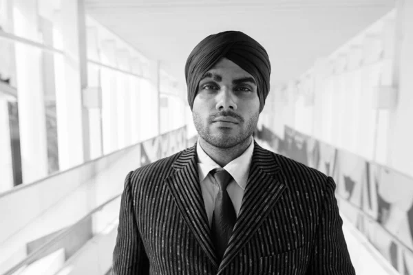 黒と白の街を探索しながらターバンを身に着けている若いハンサムなインドのシークのビジネスマンの肖像画 — ストック写真