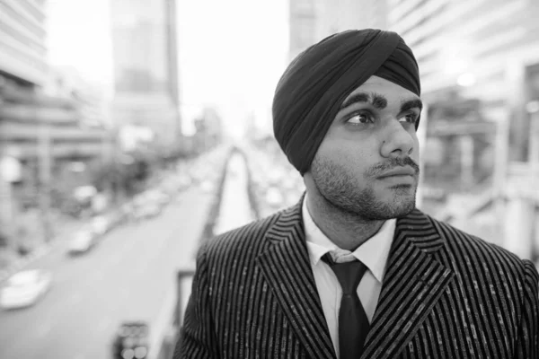 黒と白の街を探索しながらターバンを身に着けている若いハンサムなインドのシークのビジネスマンの肖像画 — ストック写真