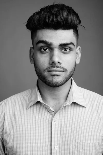 演播室拍摄的年轻英俊印度商人的灰色背景黑白照片 — 图库照片