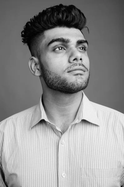 演播室拍摄的年轻英俊印度商人的灰色背景黑白照片 — 图库照片