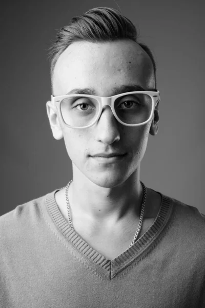 Studio Záběr Mladý Pohledný Nerd Muž Nosí Brýle Proti Šedé — Stock fotografie