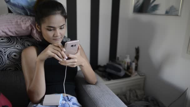 Jeune belle femme asiatique en utilisant le téléphone et de détente à la maison — Video