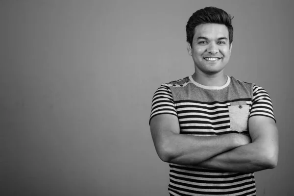 黒と白で灰色の背景に縞模様のシャツを着たインド人の男のスタジオショット — ストック写真