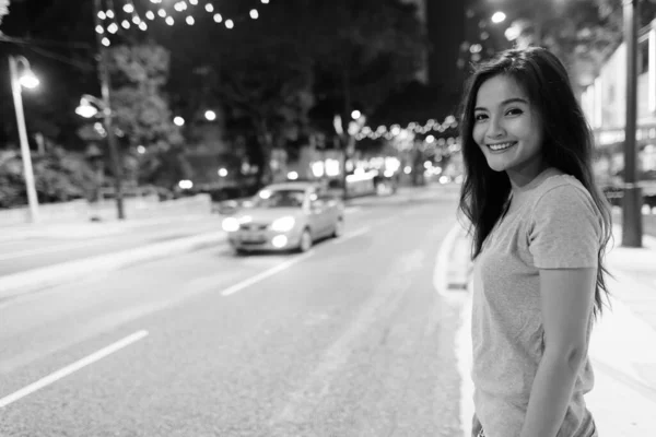 年轻美丽的亚洲女子穿着黑白相间的衣服在城市街道上漫步的画像 — 图库照片