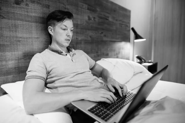 Portrait Young Handsome Man Using Laptop While Being Comfortable Bedroom — Stock Fotó