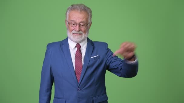 Komea vanhempi parrakas liikemies vihreällä taustalla — kuvapankkivideo