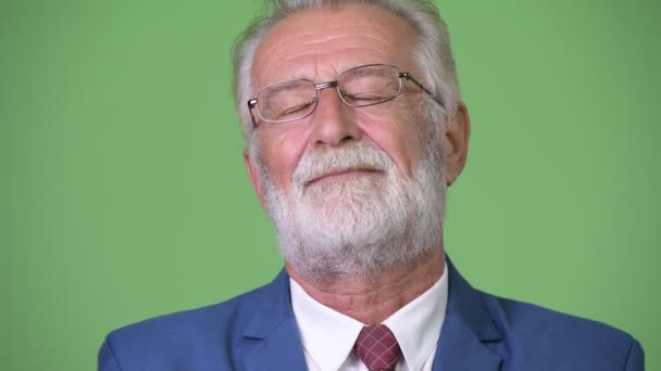 Красивий старший бородатий бізнесмен на зеленому тлі — стокове відео
