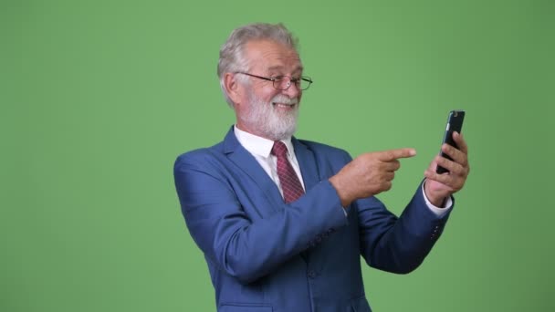 Bello anziano uomo d'affari barbuto contro sfondo verde — Video Stock