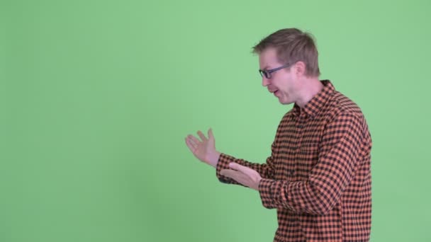 Excited young hipster man showing something to the back — Stock Video