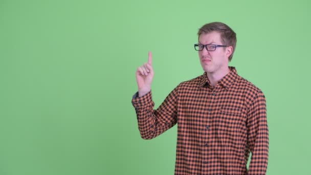 Stressaantunut nuori hipsteri mies osoittaa ylös ja antaa peukalot alas — kuvapankkivideo