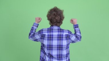 Yumrukları havada mutlu genç bir hipsterın arka görüntüsü.
