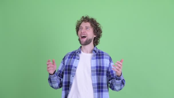 Šťastný mladý vousatý hipster muž chytit něco — Stock video