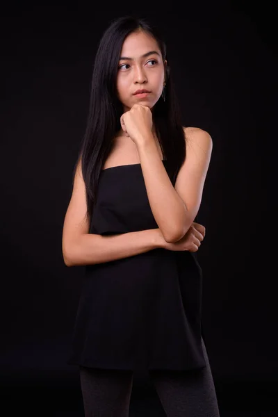 Porträtt av ung vacker asiatisk kvinna tänker — Stockfoto