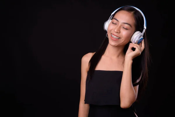 Retrato de una joven asiática feliz escuchando música con los ojos cerrados —  Fotos de Stock
