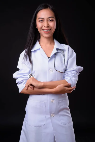 Ritratto di giovane donna asiatica felice medico sorridente con le braccia incrociate — Foto Stock