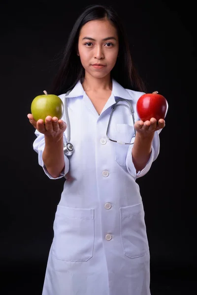 Joven asiática médico como nutricionista sosteniendo dos manzanas — Foto de Stock