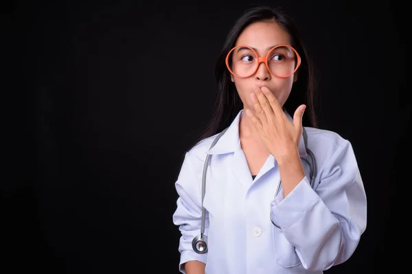 Молодая азиатка-врач в очках выглядит шокированной — стоковое фото