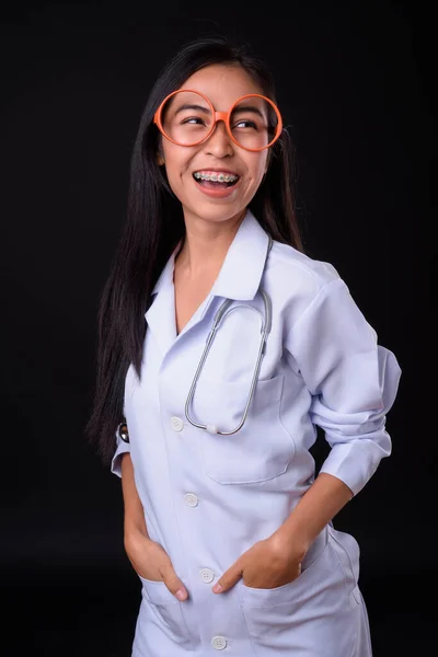 Jovem mulher asiática feliz médico com óculos pensando — Fotografia de Stock