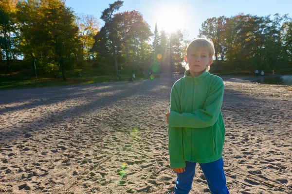 Mladý pohledný chlapec u jezera v parku — Stock fotografie