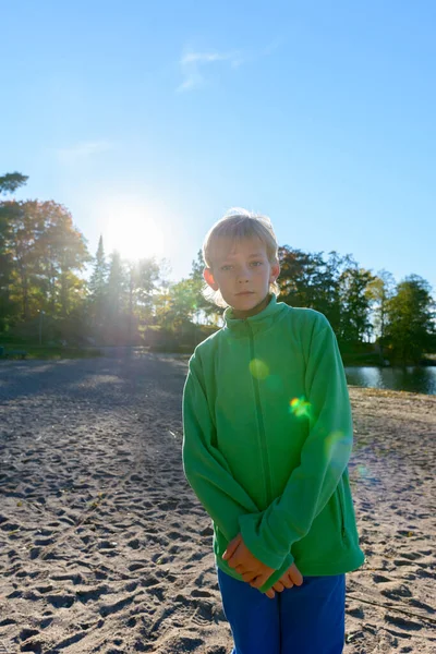Mladý pohledný chlapec u jezera v parku — Stock fotografie