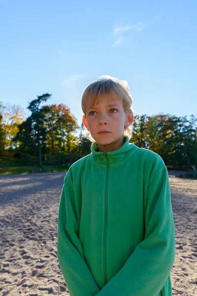 Νεαρό όμορφο αγόρι σκέφτεται κοντά στη λίμνη στο πάρκο — Φωτογραφία Αρχείου