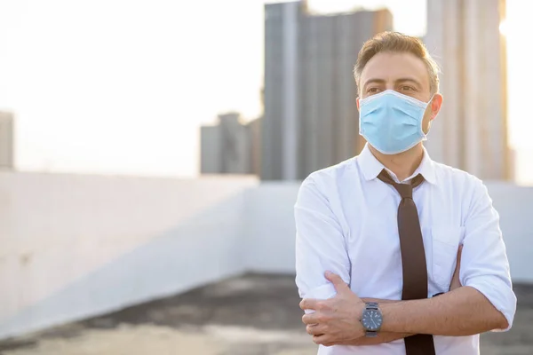 Homme d'affaires mature portant un masque pour la protection contre l'épidémie de virus de la couronne et la pollution — Photo