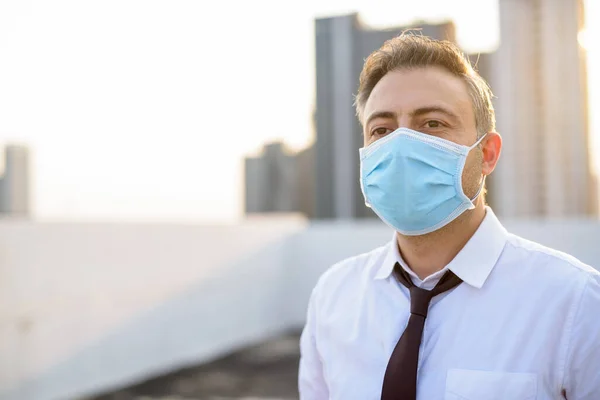 Homme d'affaires mature portant un masque pour la protection contre l'épidémie de virus de la couronne et la pollution — Photo