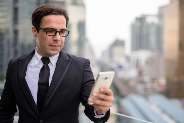 Красивый персидский бизнесмен пользуется телефоном в городе — стоковое фото