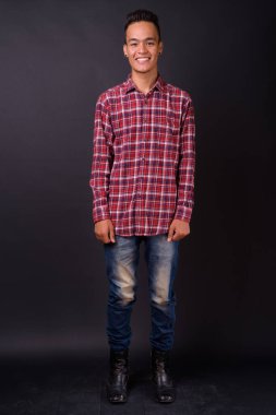 Genç, yakışıklı Hintli hippinin, siyah arka planda çekilmiş bir fotoğrafı.