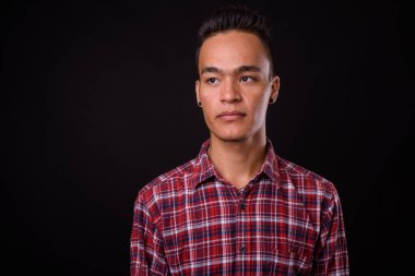 Genç, yakışıklı Hintli hippinin, siyah arka planda çekilmiş bir fotoğrafı.