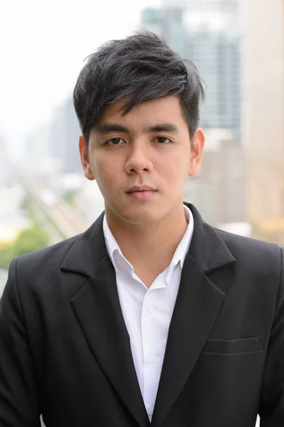 若いハンサムなフィリピン人ビジネスマンの肖像画屋外で街を眺めます — ストック写真