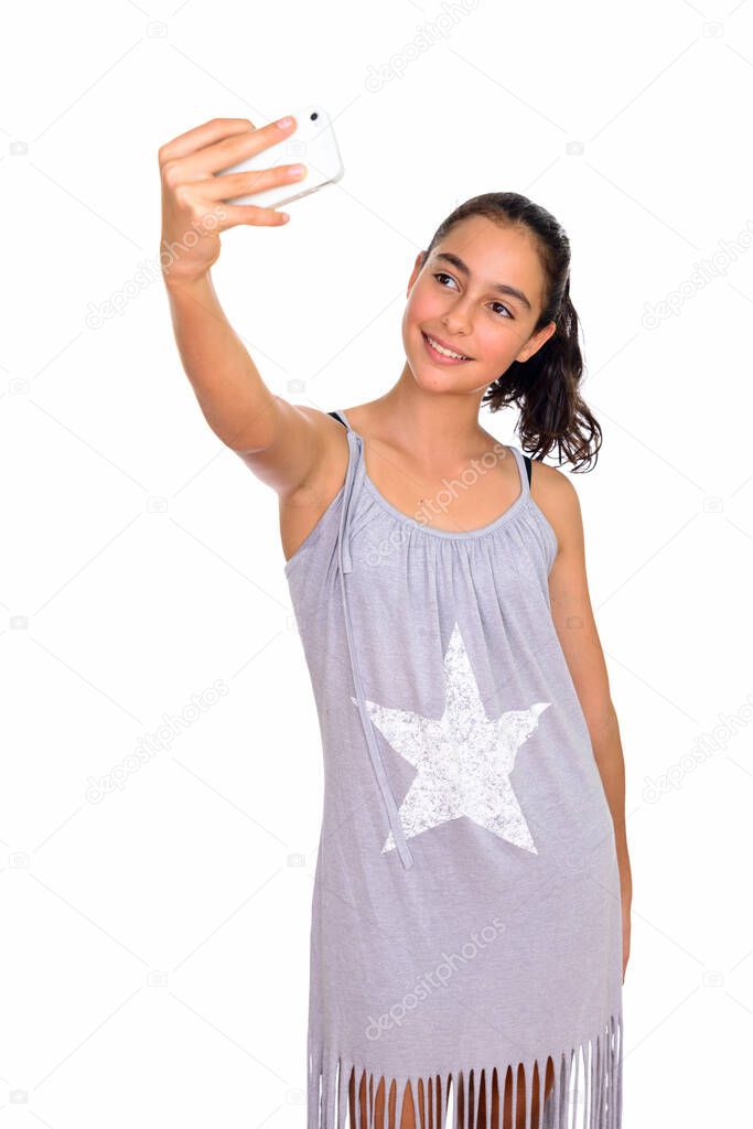 Studio shot of young beautiful teenage girl wearing sleeveless dress isolated against white background