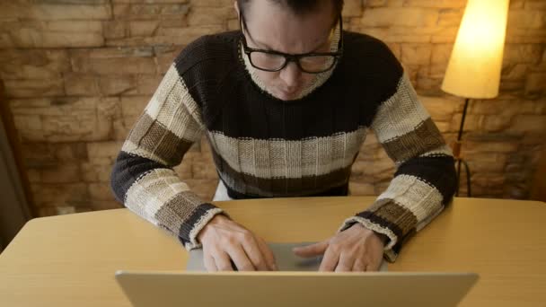 Stressad ung man ser arg när du använder laptop hemma — Stockvideo