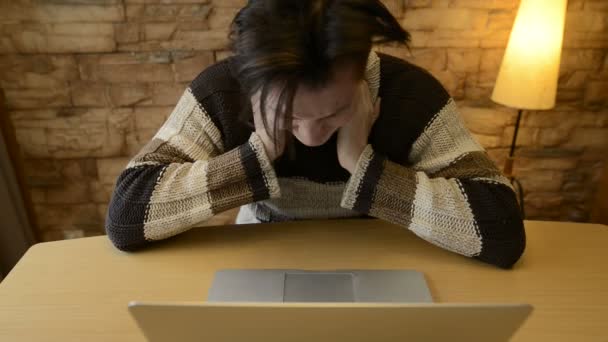 Zestresowany młodzieniec odczuwający ból szyi podczas korzystania z laptopa w domu — Wideo stockowe
